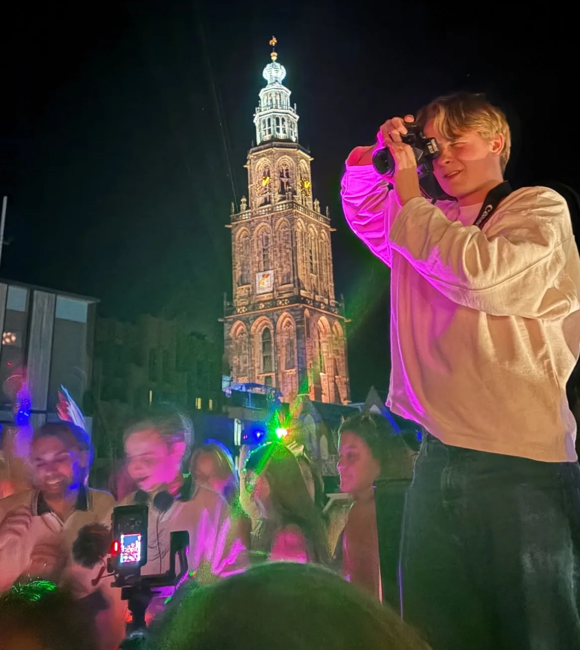 Stan fotografeert een feest in Groningen, met de verlichte Martinitoren op de achtergrond